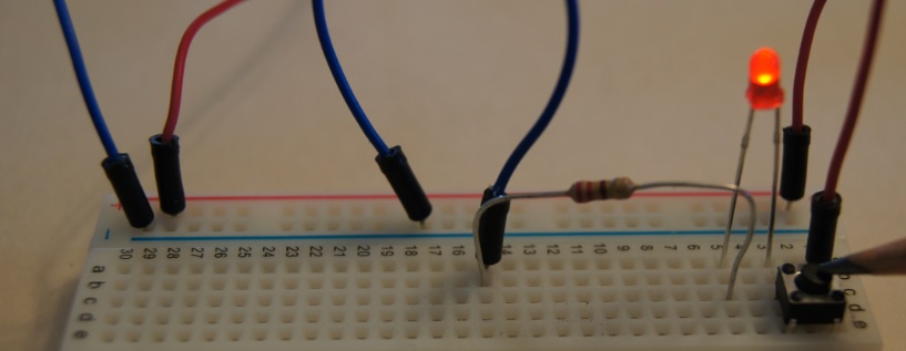Detail of a breadboard with a LED in a circuit with current flowing