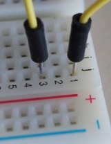 Detail of a jumper wire connecting two nodes on a breadboard
