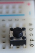 Detail of a button connecting two nodes on a breadboard