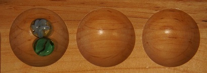 Mancala board with two stones in the first pocket.